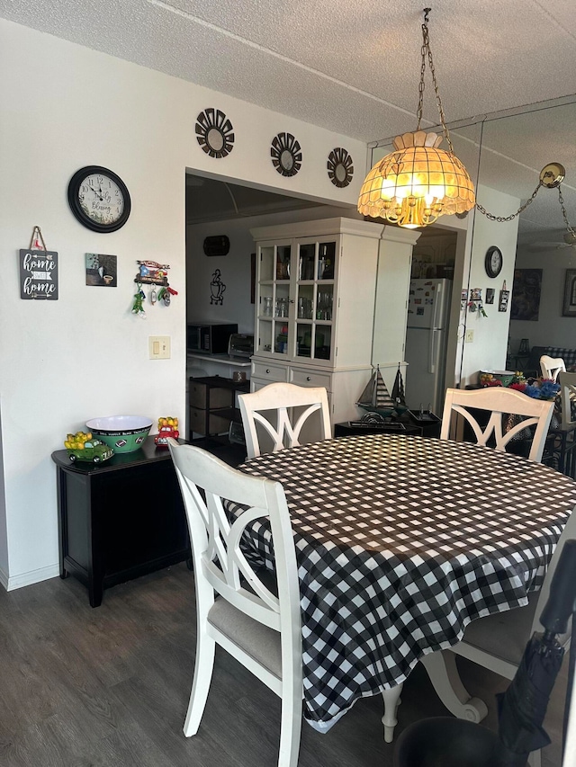 dining room with hardwood / wood-style flooring and a textured ceiling