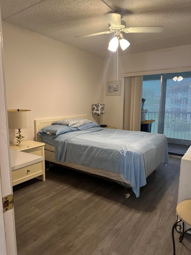 bedroom with dark wood-type flooring, a textured ceiling, and ceiling fan