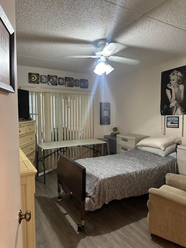 bedroom with a textured ceiling, hardwood / wood-style flooring, and ceiling fan