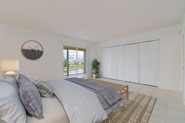 bedroom with light tile patterned floors, access to outside, and a closet