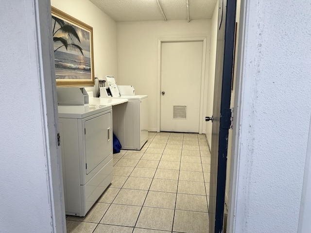 laundry room with washing machine and dryer and light tile patterned floors