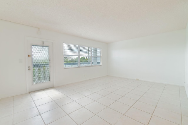 tiled spare room with a textured ceiling