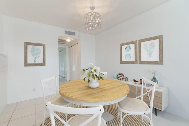 dining room featuring light tile patterned flooring and a notable chandelier