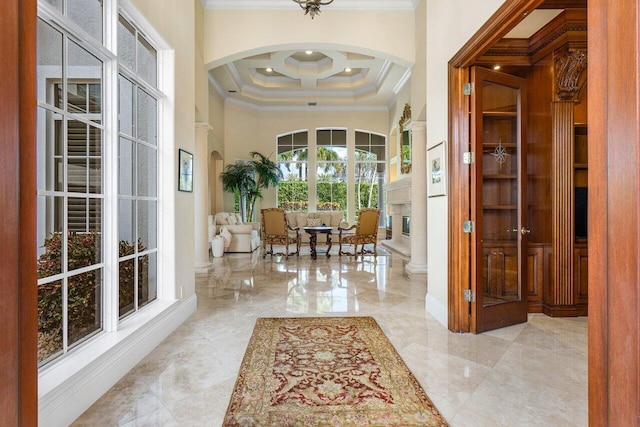 interior space with a towering ceiling, crown molding, and coffered ceiling