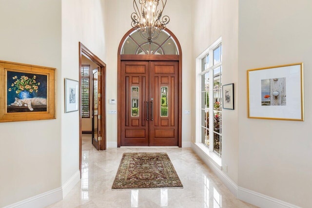 entryway featuring a towering ceiling and an inviting chandelier