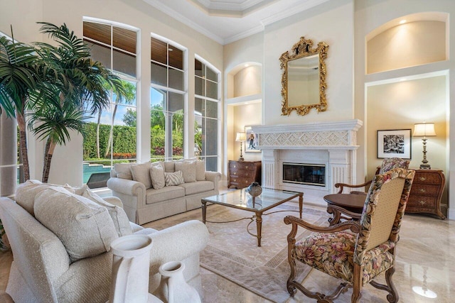 living room with built in shelves, a towering ceiling, and crown molding