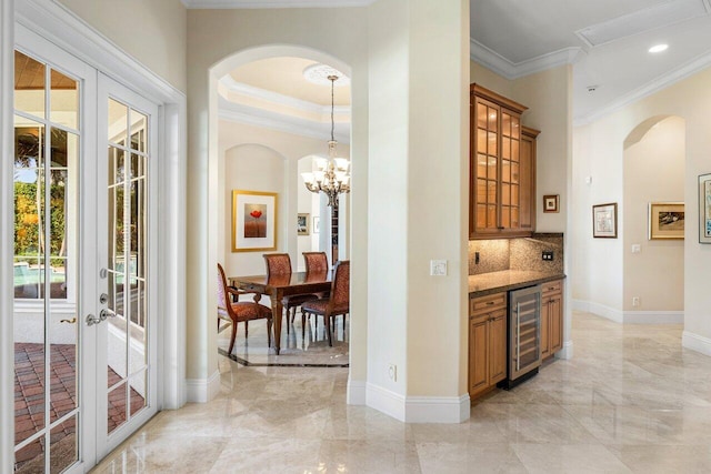 interior space featuring french doors, ornamental molding, dark stone counters, wine cooler, and decorative backsplash