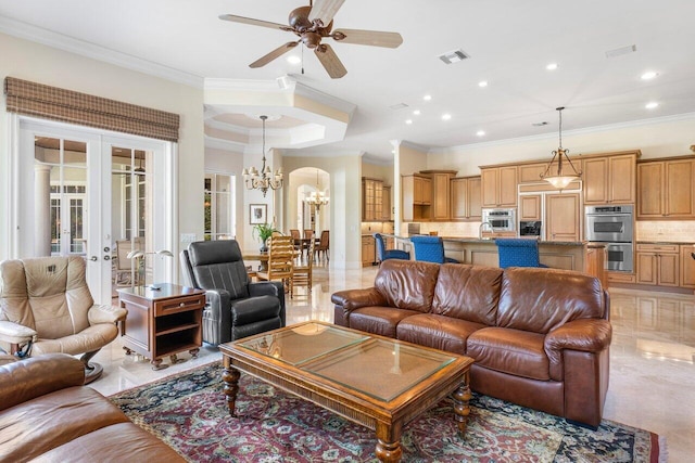 living room with french doors, ceiling fan with notable chandelier, and crown molding