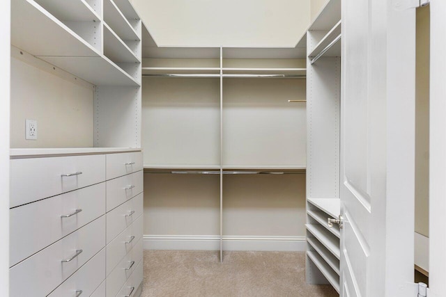 walk in closet featuring light colored carpet