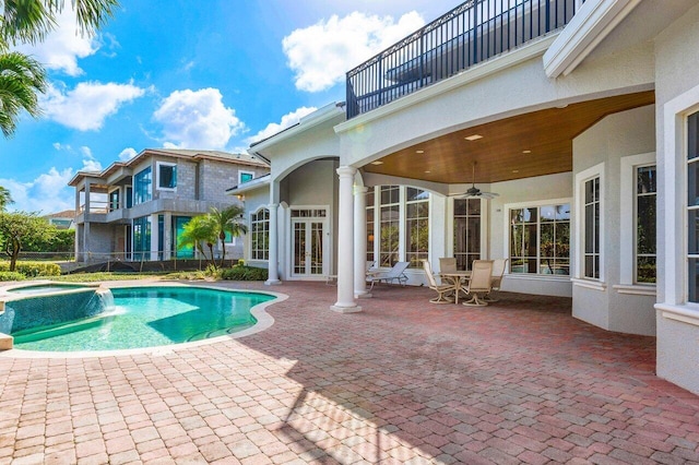 view of pool with ceiling fan, pool water feature, an in ground hot tub, and a patio area