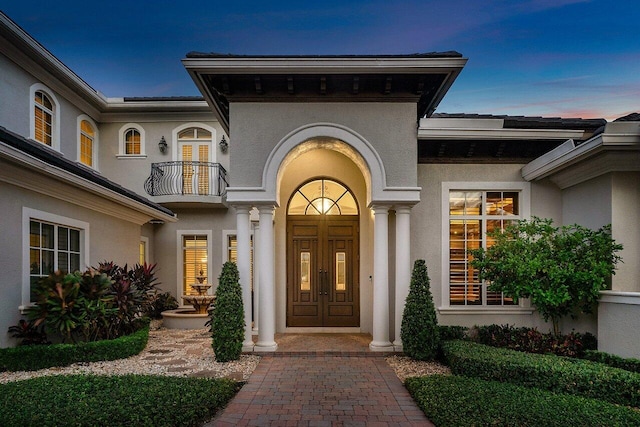 exterior entry at dusk with a balcony