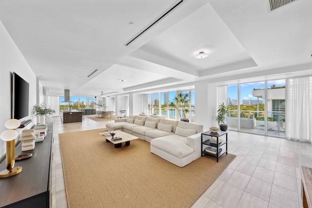 living room featuring light tile patterned floors and a tray ceiling