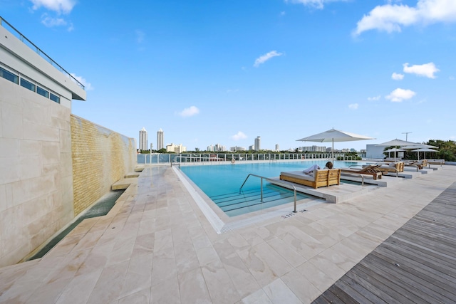 view of swimming pool featuring a patio area and a water view