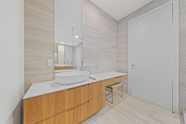 bathroom featuring vanity and tile walls