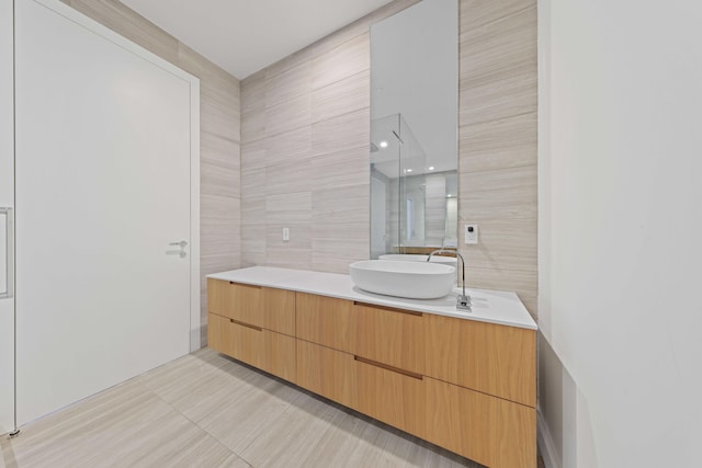 bathroom featuring tile patterned flooring, vanity, and tile walls