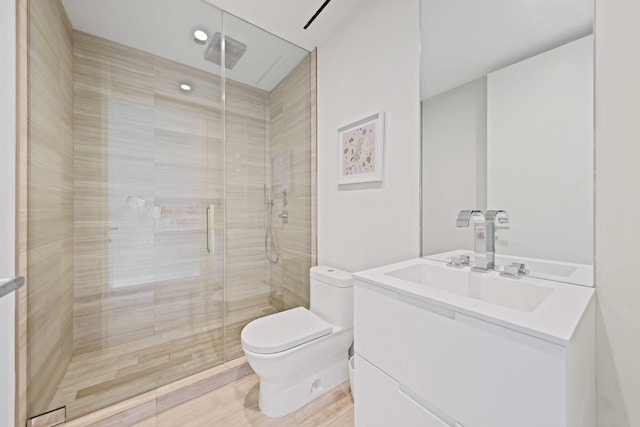 bathroom featuring hardwood / wood-style floors, vanity, an enclosed shower, and toilet