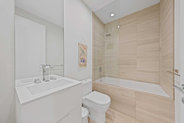 full bathroom featuring tiled shower / bath combo, toilet, and vanity