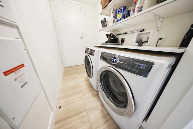 laundry area featuring washer and dryer and light tile patterned floors