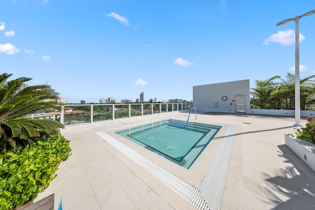 view of pool featuring a patio area and an in ground hot tub