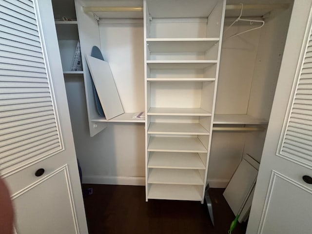 spacious closet with dark hardwood / wood-style flooring