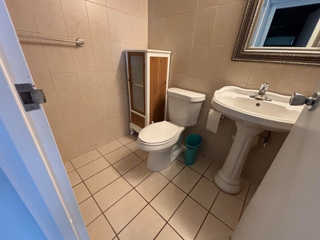 bathroom featuring tile walls, tile patterned flooring, and toilet