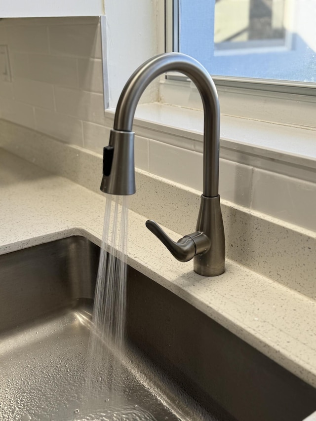 details with light stone countertops and sink