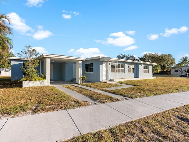 view of front of home with a front lawn and a carport