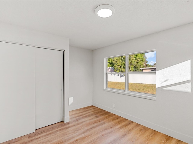 unfurnished bedroom featuring light hardwood / wood-style flooring and a closet