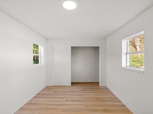 unfurnished bedroom featuring light hardwood / wood-style floors and a closet