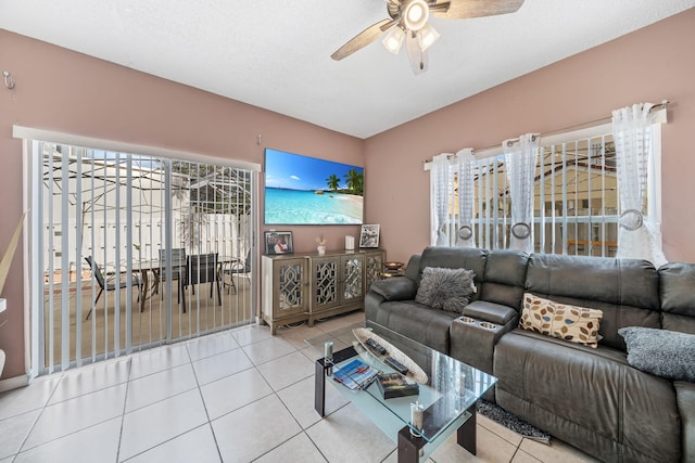 living room with light tile patterned flooring, a textured ceiling, and ceiling fan