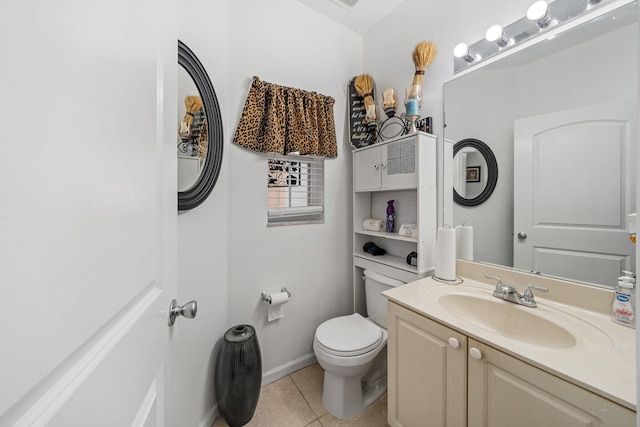 bathroom with toilet, vanity, and tile patterned flooring