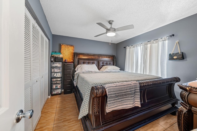 tiled bedroom featuring a textured ceiling, ceiling fan, and a closet