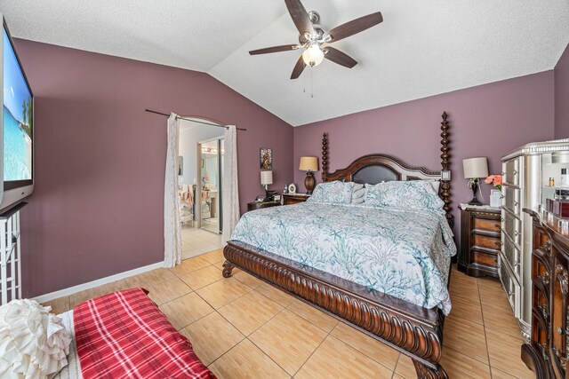 tiled bedroom with connected bathroom, lofted ceiling, a textured ceiling, and ceiling fan