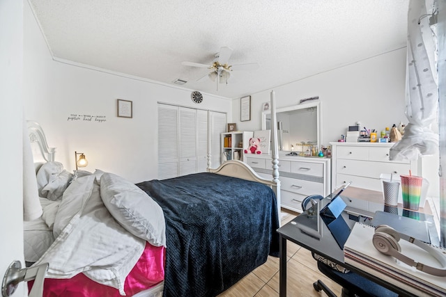 bedroom with ceiling fan, a textured ceiling, a closet, and light hardwood / wood-style flooring