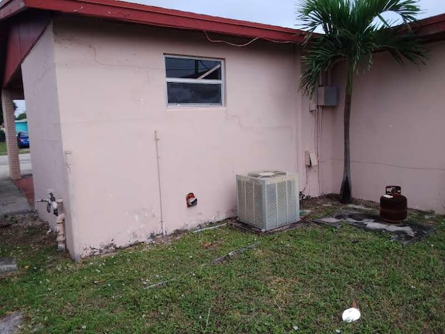 view of home's exterior featuring central AC and a yard