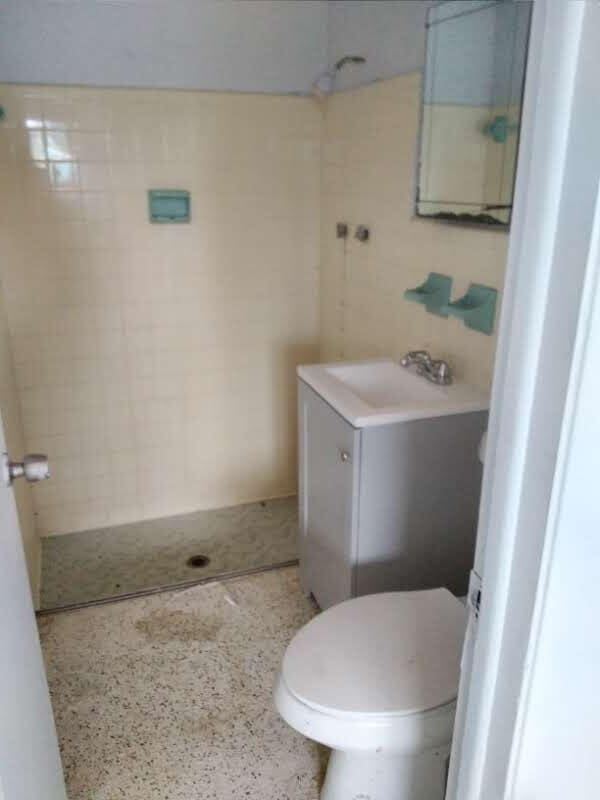 bathroom with toilet, sink, and tiled shower