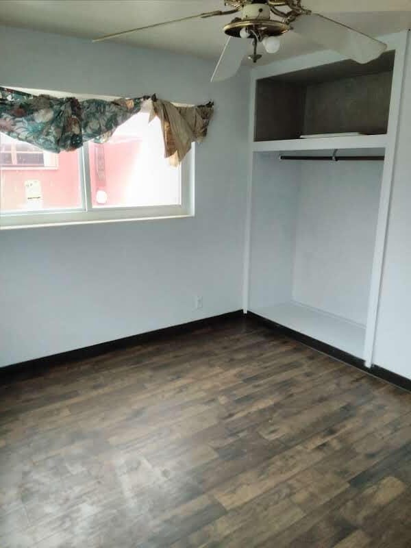 unfurnished bedroom featuring ceiling fan and dark hardwood / wood-style floors