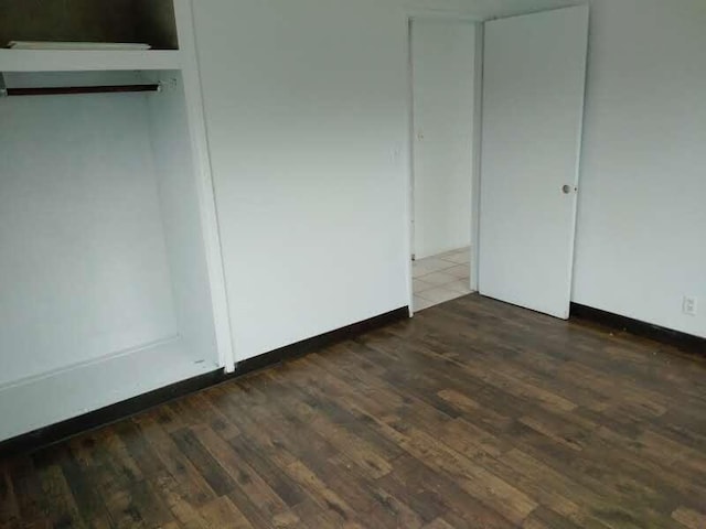 unfurnished bedroom with dark hardwood / wood-style floors