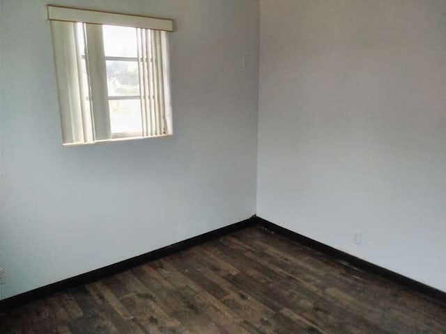 spare room with dark hardwood / wood-style flooring