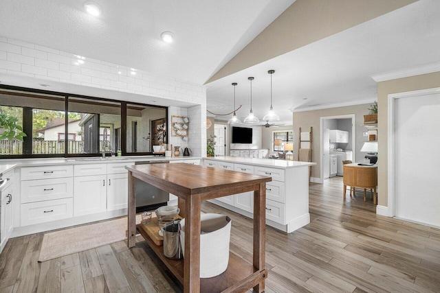 kitchen with white cabinets, decorative light fixtures, independent washer and dryer, and kitchen peninsula