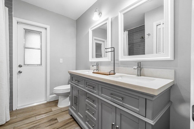 bathroom featuring hardwood / wood-style floors, vanity, curtained shower, and toilet