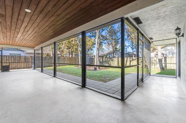 unfurnished sunroom featuring plenty of natural light and wood ceiling