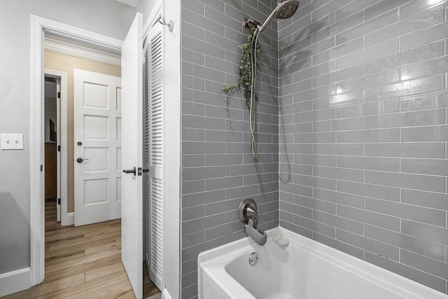 bathroom with tiled shower / bath combo and hardwood / wood-style flooring