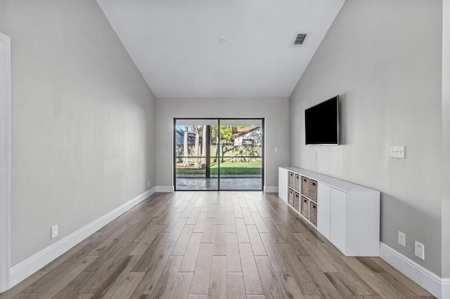 unfurnished living room with light hardwood / wood-style floors and lofted ceiling