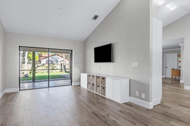 unfurnished living room featuring light wood-type flooring and high vaulted ceiling