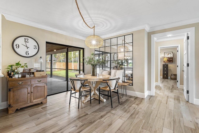 dining room featuring an inviting chandelier, ornamental molding, and light hardwood / wood-style flooring