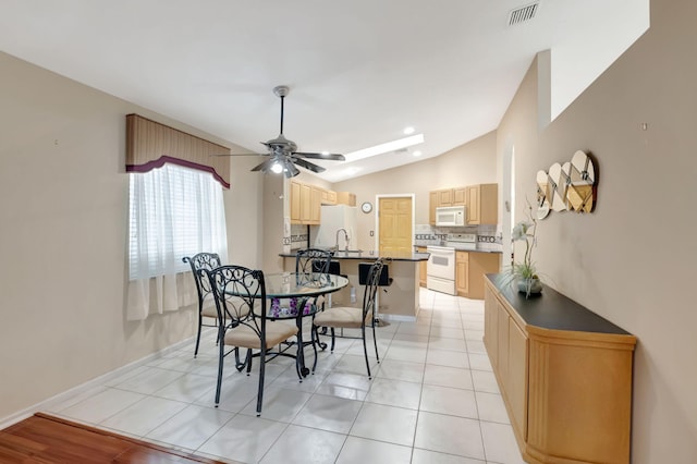 dining room featuring lofted ceiling, light tile patterned floors, ceiling fan, and sink