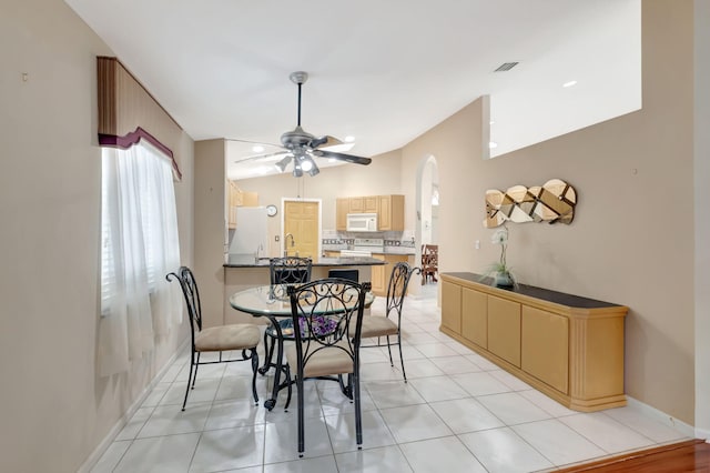 tiled dining room with ceiling fan, lofted ceiling, and sink