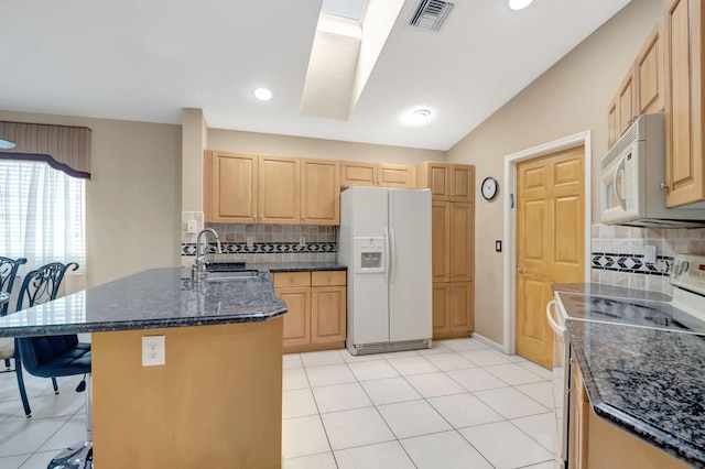 kitchen with light brown cabinetry, sink, white appliances, and tasteful backsplash