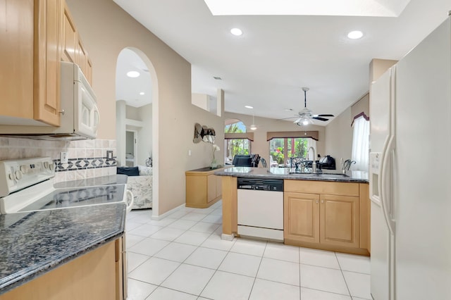 kitchen with tasteful backsplash, dark stone counters, sink, and white appliances